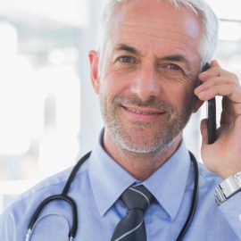 20640566 – smiling doctor speaking on the phone 20640566 - smiling doctor speaking on the phone